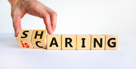 Sharing is caring symbol. Businessman turns wooden cubes with words 'sharing is caring'. Beautiful...