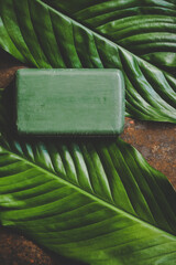 A piece of natural soap made from oils on green leaves, mockup - 433523690