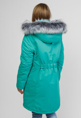 young woman in winter clothes on white background. Photo concept for advertising a down jacket