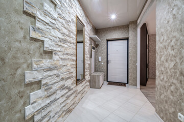 empty corridor in interior of entrance hall of modern apartments, office or clinic with brick wall