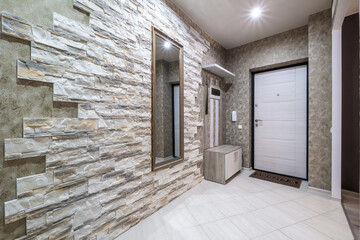 empty corridor in interior of entrance hall of modern apartments, office or clinic with brick wall
