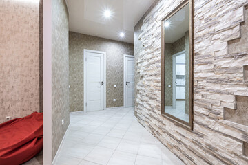 empty corridor in interior of entrance hall of modern apartments, office or clinic with brick wall