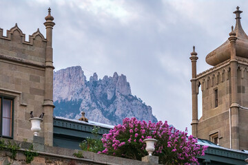 The walls and towers of the old palace on the background of a cloudy sky