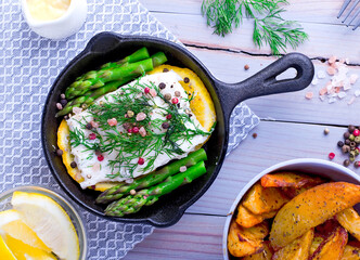 cod roasted on lemon with dill, colored pepper and asparagus, served with béchamel sauce, plus potato slices with spices