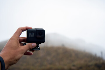 hand holding the Gopro Digital camera, shoot of landscape photo
