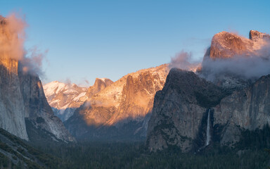 winter sunset shot of snow on yosemite's half dome as storm clouds clear from yosemite national park