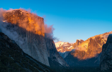 winter sunset shot of yosemite's el capitan and half dome as storm clouds clear from yosemite national park