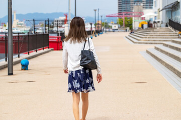 海岸を歩く女性の後ろ姿