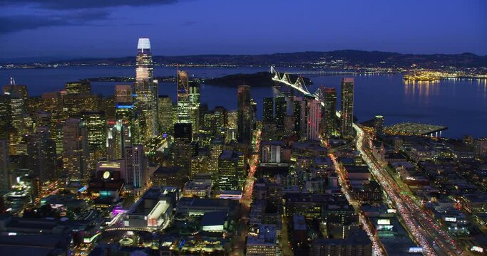 
San Francisco Financial District aerial view. Famous skyscrapers at dusk. Bay bridge in the background. California, United States. Shot in 8K.