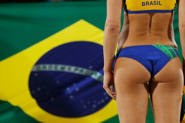 Brazilian woman wear bikini swim suit, beach volley ball professional player concept, standing with brazil national flag at background, close-up detail shot