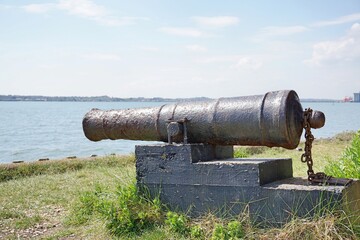 Old cannon on block faces river.