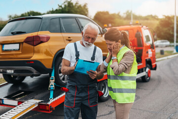 Handsome senior man working in towing service on the road. Roadside assistance concept...