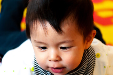 Closeup shot of a cute Swiss baby boy playing with toys on a rubber mat