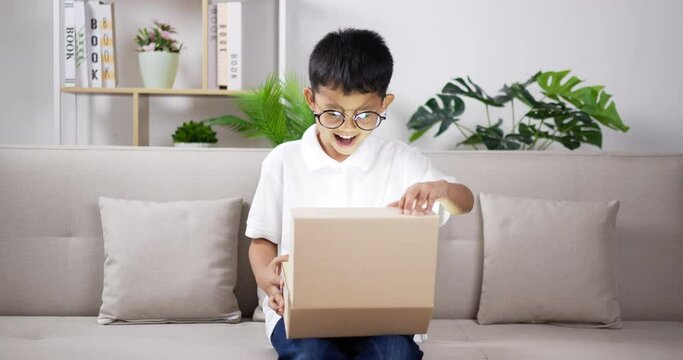 Boy wearing glasses opening gift box