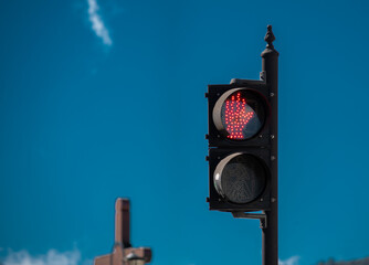 detail view of traffic light with red hand, blue sky in background