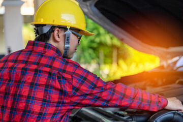 Asian engineer holding digital tablet. mechanic in uniform Check Car problem. Checking engine with tablet. 5 Generation wireless technology.