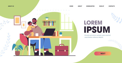 father using laptop and holding little son fatherhood parenting concept dad spending time with kid