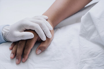 Doctors wear medical gloves holding touching hands man patient with love, care, helping, encourage and empathy at nursing hospital ward.healthy strong medical concept