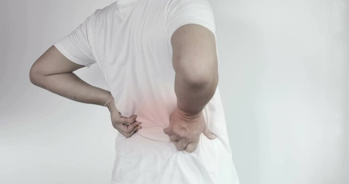 Waist Pain or Backache. Back view of a man in a white shirt having problems with his waist muscle. office syndrome healthcare concept
