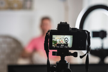 detrás de cámara de un hombre siendo entrevistado con luces y micrófonos para un blog