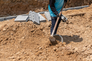 Workers dig the soil to adjust the construction area.