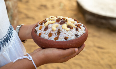 Kiripidu offering at Jaya Sri Maha Bodhi, Anuradhapura. White dresses girl holding a bowl of milk rice and decorated with fruits on top.