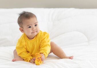 Portrait and focus to eye adorable baby child on white bed in bedroom look at camera with bright soft light in morning in background