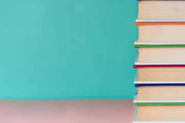 Stack of books in library room and blurred bookshelf for business and educational background, back to school concept
