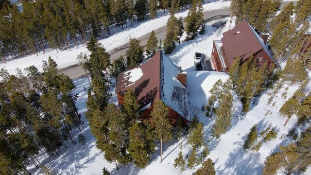 Aerial view towards a wooden cabin in Breckenridge, Colorado - tilt, drone shot