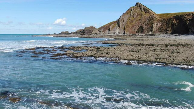 Aerial coastal of the waves in the sea and rocks at Spekes Mill beach in Devon