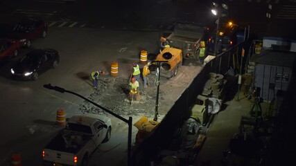 A road construction crew is breaking up cement on the street, preparing to make road work improvements.