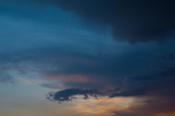 Beautiful scenery of black, dark blue and orange clouds in evening after heavy rainfall
