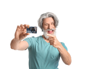 Fototapeta na wymiar Senior man pointing at gift card on white background