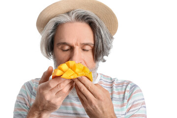 Senior man eating fresh mango on white background