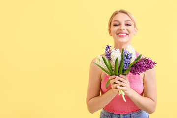 Beautiful young woman with hyacinth flowers on color background