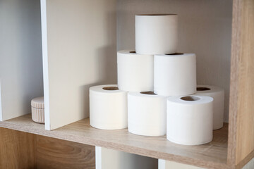 Rolls of toilet paper on shelf in bathroom