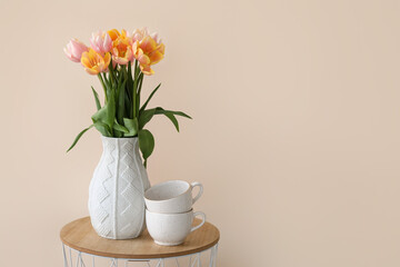 Bouquet of beautiful tulip flowers on table near color wall