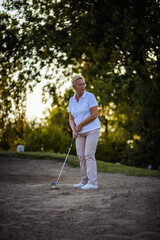 Senior woman playing golf. Golfer.