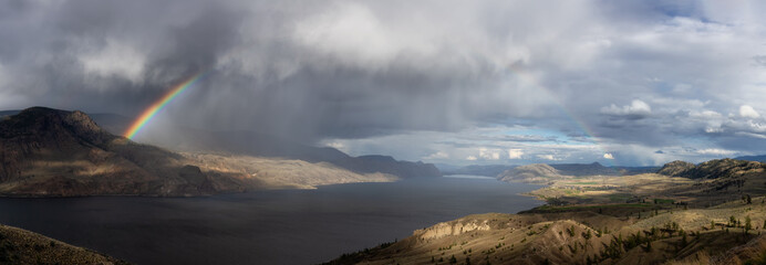 Panoramic View of Canadian Mountain Landscape in Desert by the Lake. Dramatic Stormy and Rainy Weather with Rainbow. Near Kamloops, British Columbia, Canada.