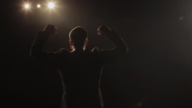 A Man Is Coming On Stage And Waving His Hands. The Spotlight Is Shining On Him. 4K