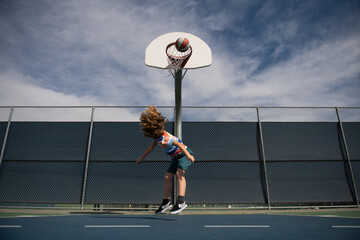 Fototapeta na wymiar Happy little boy kid playing basketball on playground.