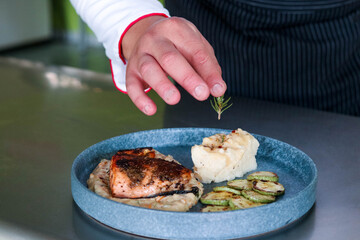 Chef colocando romero sobre puré de papa 