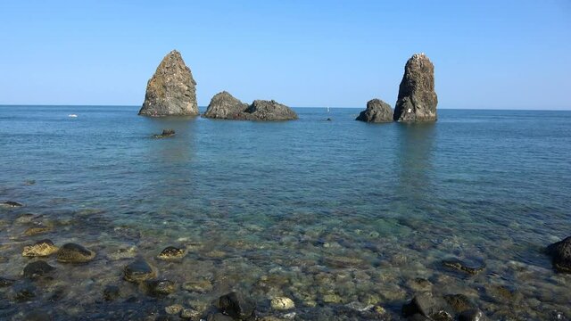 View of the Faraglioni of Acitrezza. Rocks of the Cyclops, typical lava stacks. Sicily, Italy. Footage 4k
