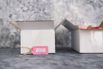 women-owned businesses tag with online order delivery parcel, supporting equality and female entrepreneurs
