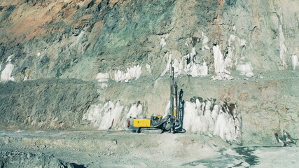 Drilling machine in the middle of an open-pit mine