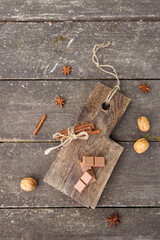 Pieces of chocolate, cinnamon sticks and star anise on a wooden board. High quality photo