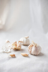 Close-up of garlic on a white tablecloth. Home plant growing, cooking and spices. Sunlight and trending hard shadows. High quality photo