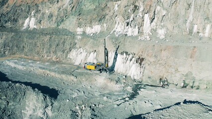 Quarry site with a drilling machine filmed from above