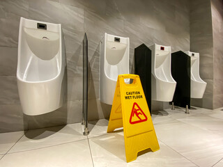 Wet floor alert sign during cleaning process in public toilet