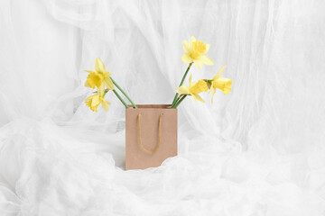 beautiful fresh yellow daffodils in a craft package on a white background. gift concept for holiday